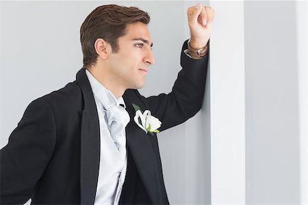 simsearch:400-04171391,k - Serious bridegroom looking out of the window leaning against a wall Stock Photo - Budget Royalty-Free & Subscription, Code: 400-07140325