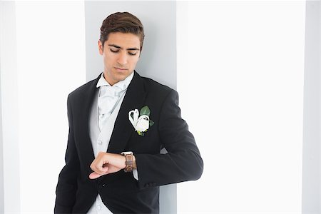 simsearch:400-04171391,k - Serious bridegroom leaning against wall watching his clock Stock Photo - Budget Royalty-Free & Subscription, Code: 400-07140329