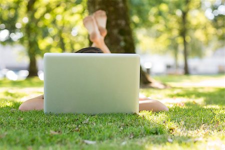 Brunette lying on the grass typing at her laptop in a park on a sunny day Stock Photo - Budget Royalty-Free & Subscription, Code: 400-07140639