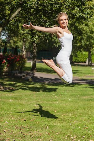 person spreading arms - Side view of young cheerful woman jumping spreading her arms in a park Stock Photo - Budget Royalty-Free & Subscription, Code: 400-07140824