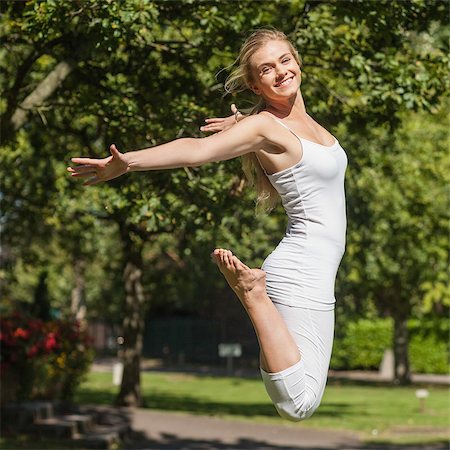 person spreading arms - Side view of young fit woman jumping spreading her arms in a park Stock Photo - Budget Royalty-Free & Subscription, Code: 400-07140823