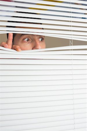 Beautiful brown male eyes spying through roller blind Fotografie stock - Microstock e Abbonamento, Codice: 400-07141040