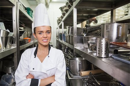 restaurant work teenager - Young cheerful chef standing arms crossed between shelves in professional kitchen Photographie de stock - Aubaine LD & Abonnement, Code: 400-07141077