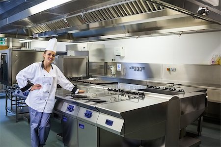 fornellino elettrico - Young content chef standing next to work surface in professional kitchen Fotografie stock - Microstock e Abbonamento, Codice: 400-07141094