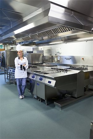fornellino elettrico - Young happy chef standing next to work surface in professional kitchen Fotografie stock - Microstock e Abbonamento, Codice: 400-07141096