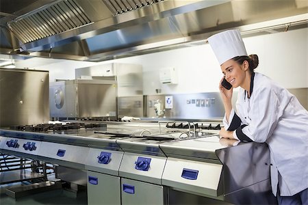fornellino elettrico - Young happy chef standing next to work surface phoning in professional kitchen Fotografie stock - Microstock e Abbonamento, Codice: 400-07141098