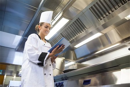 Young smiling chef using tablet standing in professional kitchen Stock Photo - Budget Royalty-Free & Subscription, Code: 400-07141105