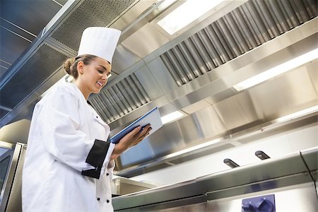 Young cheerful chef using tablet standing in professional kitchen Stock Photo - Budget Royalty-Free & Subscription, Code: 400-07141106