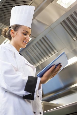simsearch:400-07468062,k - Young content chef using tablet standing in professional kitchen Stockbilder - Microstock & Abonnement, Bildnummer: 400-07141107