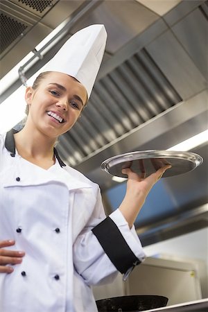 Young cheerful chef holding tray in professional kitchen Stock Photo - Budget Royalty-Free & Subscription, Code: 400-07141109