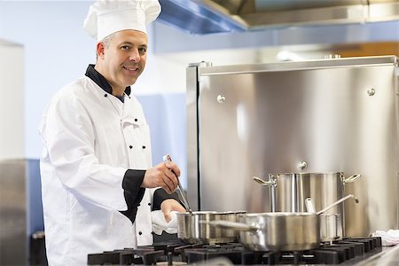 simsearch:400-07141137,k - Smiling head chef stirring in pot in professional kitchen Stock Photo - Budget Royalty-Free & Subscription, Code: 400-07141129