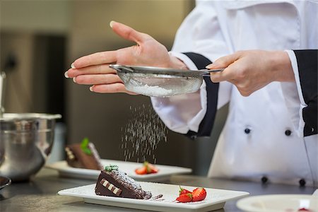 simsearch:6109-08489807,k - Female chef finishing a dessert plate with icing sugar Foto de stock - Super Valor sin royalties y Suscripción, Código: 400-07141188