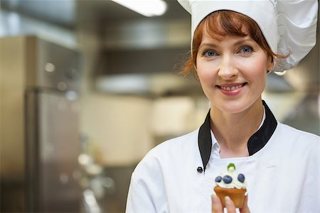 simsearch:649-07063042,k - Pretty happy head chef holding blueberry dessert in professional kitchen Photographie de stock - Aubaine LD & Abonnement, Code: 400-07141182