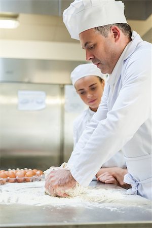 pastry chef uniform for women - Focused head chef kneading dough in professional kitchen Stock Photo - Budget Royalty-Free & Subscription, Code: 400-07141309