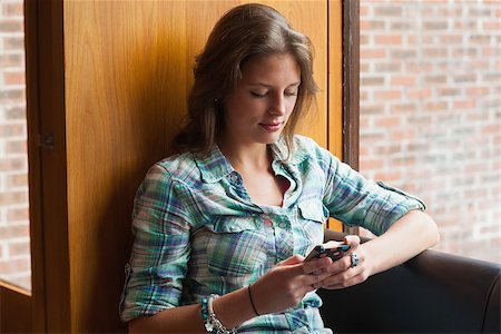 students campus phones - Casual smiling student sitting next to window texting in college Stock Photo - Budget Royalty-Free & Subscription, Code: 400-07141837