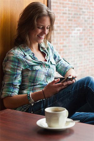 students campus phones - Casual cheerful student sitting next to window texting in college Stock Photo - Budget Royalty-Free & Subscription, Code: 400-07141838