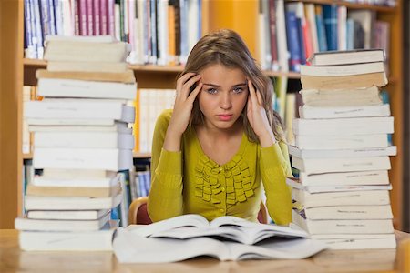 simsearch:400-04295114,k - Tired pretty student studying between piles of books in library Photographie de stock - Aubaine LD & Abonnement, Code: 400-07141905