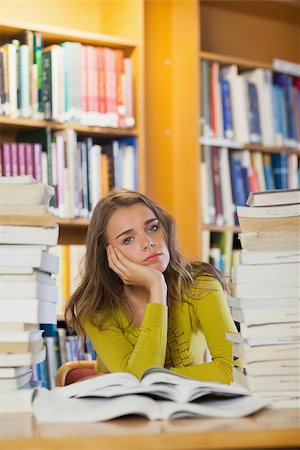 simsearch:400-04295114,k - Tired beautiful student studying between piles of books in library Photographie de stock - Aubaine LD & Abonnement, Code: 400-07141909