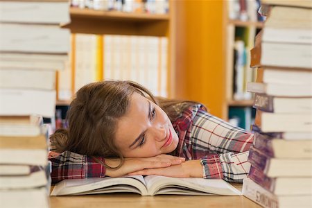 simsearch:400-04295114,k - Tired pretty student resting head on table between piles of books in library Photographie de stock - Aubaine LD & Abonnement, Code: 400-07141919