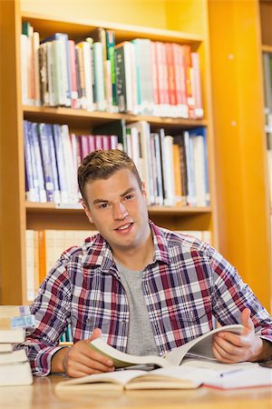 simsearch:6109-07497514,k - Handsome happy student studying his books in library Stockbilder - Microstock & Abonnement, Bildnummer: 400-07141934