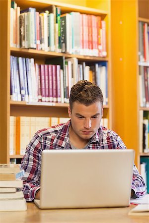 simsearch:400-07141917,k - Handsome focused student using laptop in library Stock Photo - Budget Royalty-Free & Subscription, Code: 400-07141941
