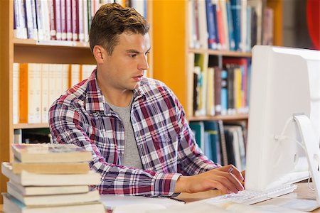 simsearch:400-07141917,k - Handsome focused student using computer in library Stock Photo - Budget Royalty-Free & Subscription, Code: 400-07141942
