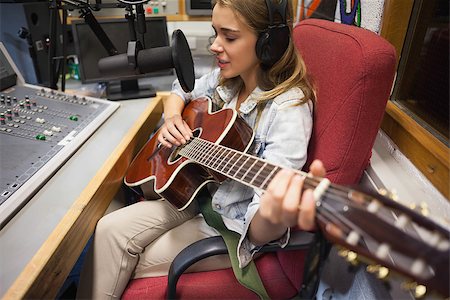 Focused pretty singer recording and playing guitar in studio at college Stock Photo - Budget Royalty-Free & Subscription, Code: 400-07141987