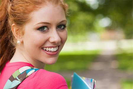 simsearch:400-07267769,k - Gorgeous cheerful student holding notebooks looking at camera on campus at college Stock Photo - Budget Royalty-Free & Subscription, Code: 400-07142026