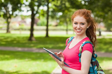 simsearch:400-07267769,k - Gorgeous smiling student using tablet on campus at college Stock Photo - Budget Royalty-Free & Subscription, Code: 400-07142028