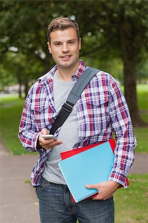 students campus phones - Handsome smiling student standing and texting on campus at college Stock Photo - Budget Royalty-Free & Subscription, Code: 400-07142054