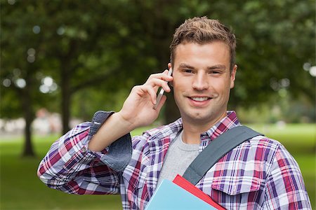 students campus phones - Handsome cheerful student standing and phoning on campus at college Stock Photo - Budget Royalty-Free & Subscription, Code: 400-07142056