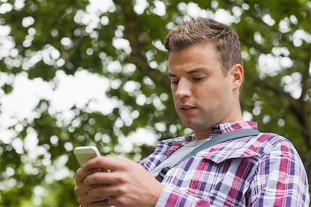 students campus phones - Handsome worried student standing and texting on campus at college Stock Photo - Budget Royalty-Free & Subscription, Code: 400-07142057