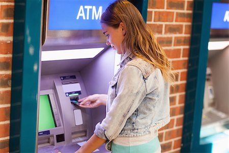 prelievo - Pretty brunette student withdrawing cash at an ATM Fotografie stock - Microstock e Abbonamento, Codice: 400-07142141