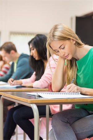 simsearch:400-07180633,k - Side view of a group of young students writing notes in the classroom Foto de stock - Super Valor sin royalties y Suscripción, Código: 400-07142439