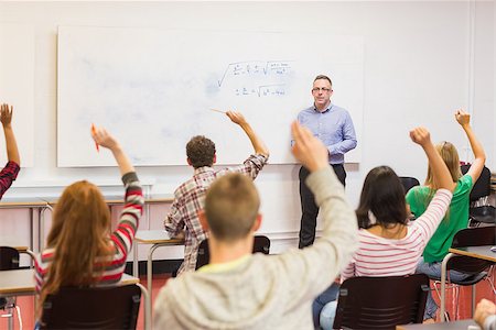 Rear view of students with hands raised with a teacher in the classroom Stock Photo - Budget Royalty-Free & Subscription, Code: 400-07142464