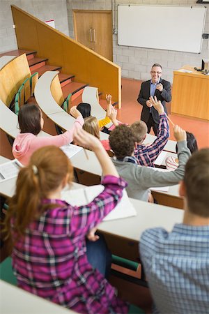 students in lecture hands raised - Rear view of students raising hands with a teacher in the college lecture hall Stock Photo - Budget Royalty-Free & Subscription, Code: 400-07142509