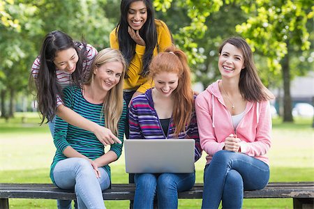 Group of cheerful young college girls using laptop in the park Stock Photo - Budget Royalty-Free & Subscription, Code: 400-07142618