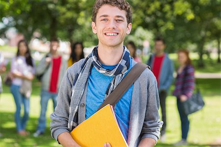 Portrait of college boy holding books with blurred students standing in the park Stock Photo - Budget Royalty-Free & Subscription, Code: 400-07142647