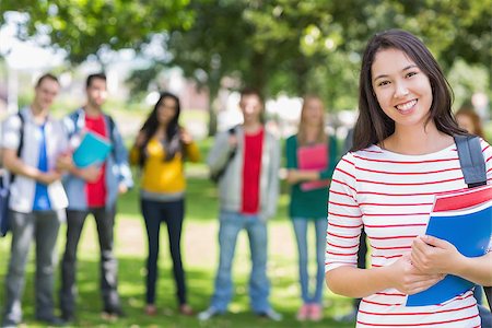 Portrait of college girl holding books with blurred students standing in the park Stock Photo - Budget Royalty-Free & Subscription, Code: 400-07142652