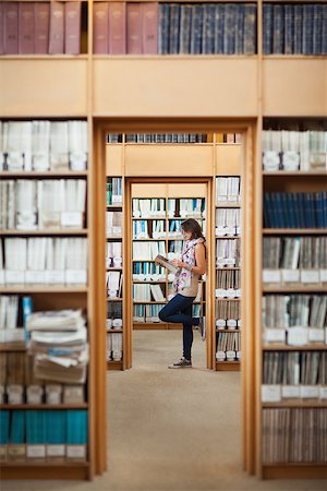 Full length side view of a female student reading a book in the library Stock Photo - Budget Royalty-Free & Subscription, Code: 400-07142691