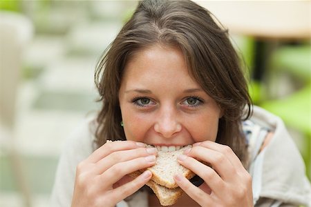 Close up portrait of a smiling female student eating sandwich in the cafeteria Stock Photo - Budget Royalty-Free & Subscription, Code: 400-07142804