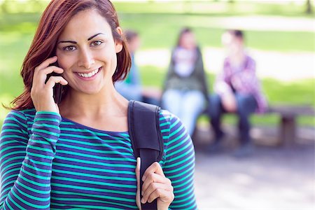 students campus phones - Close up of college girl using mobile phone with blurred students sitting in the park Stock Photo - Budget Royalty-Free & Subscription, Code: 400-07143534