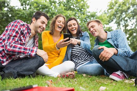 students campus phones - Group of happy young college students looking at mobile phone in the park Stock Photo - Budget Royalty-Free & Subscription, Code: 400-07143585
