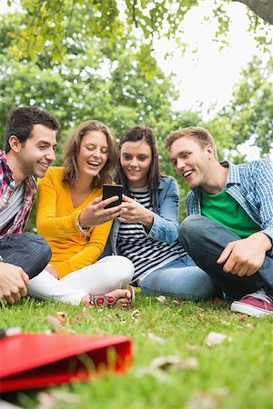 students campus phones - Group of happy young college students looking at mobile phone in the park Stock Photo - Budget Royalty-Free & Subscription, Code: 400-07143586