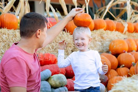 smiling excited boy and his father at the pumpkin patch having fun together Foto de stock - Super Valor sin royalties y Suscripción, Código: 400-07165147