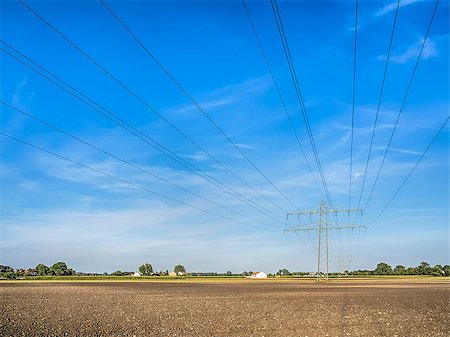 simsearch:400-07055373,k - Power cable and power pole over a field under a blue sky with white clouds Fotografie stock - Microstock e Abbonamento, Codice: 400-07165262