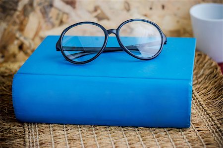 Book and eyeglass on table Stockbilder - Microstock & Abonnement, Bildnummer: 400-07165860