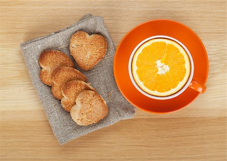 simsearch:400-07090594,k - Cup with orange and heart shaped cookies on wooden table. View from above Foto de stock - Super Valor sin royalties y Suscripción, Código: 400-07166710