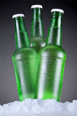 simsearch:400-07165373,k - Three green beer bottles sitting on ice over a gray background. Fotografie stock - Microstock e Abbonamento, Codice: 400-07166933