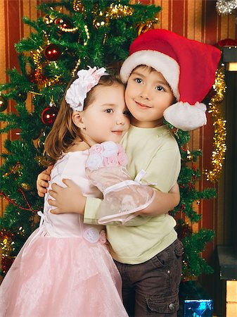 sister hugs baby - two beautiful child stand near christmas tree Photographie de stock - Aubaine LD & Abonnement, Code: 400-07167045